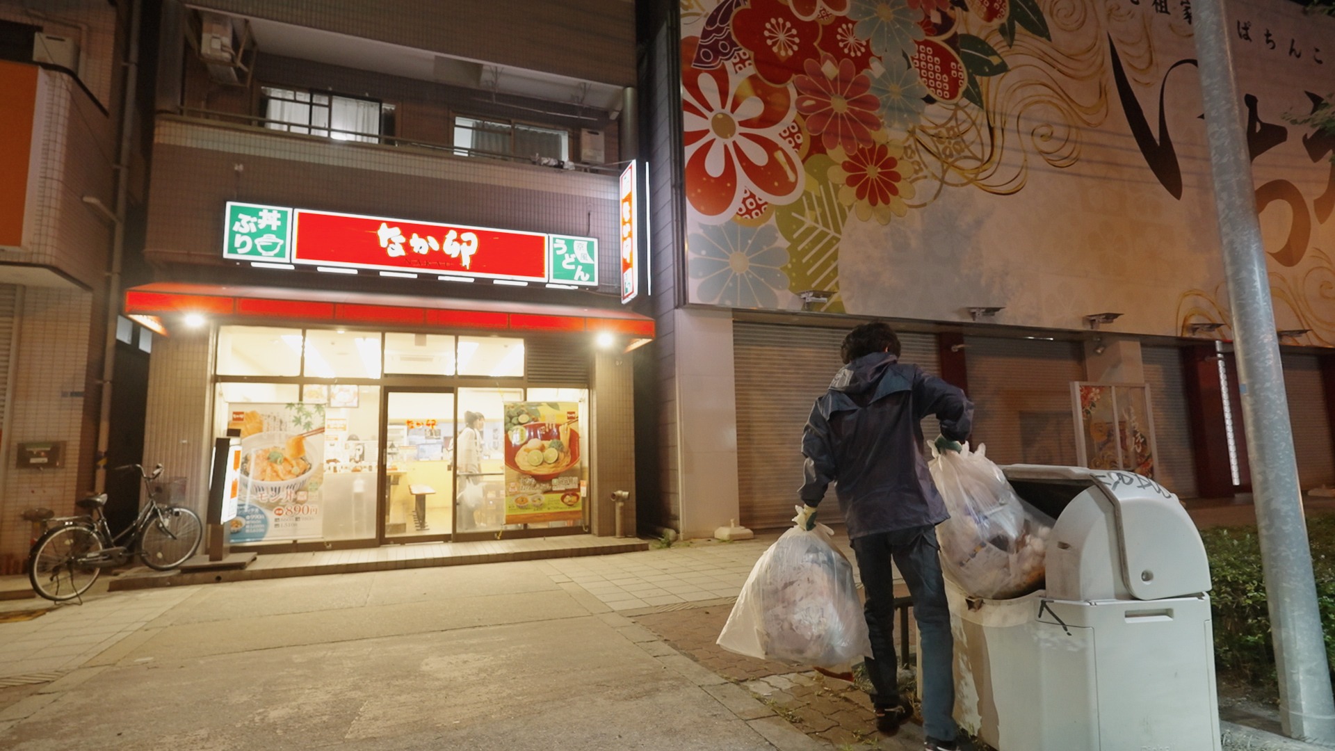 飲食チェーン店前でゴミ袋を回収するスタッフ
