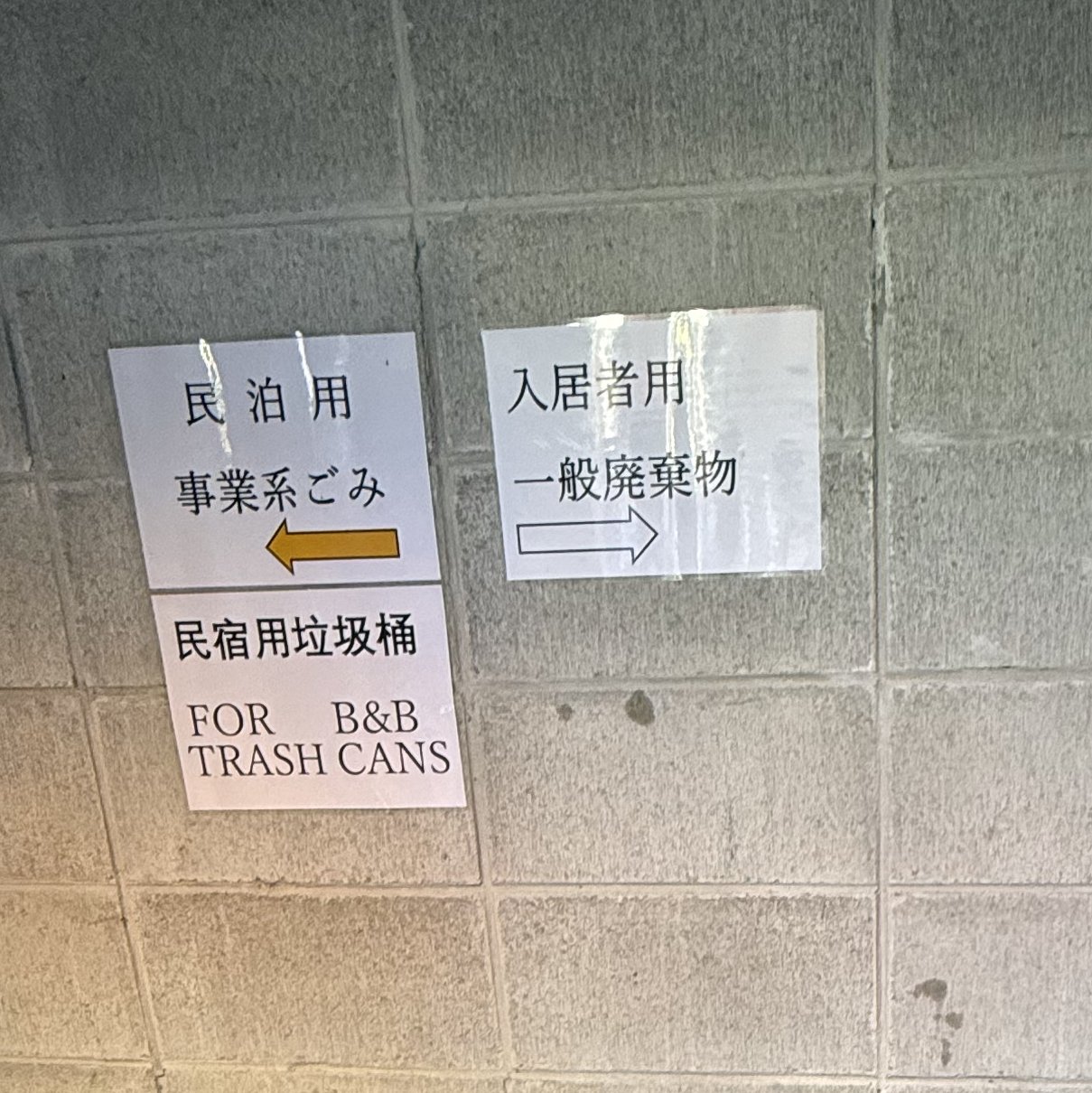 ごみ置き場の貼り紙。民泊用の事業系ごみと入居者用の一般廃棄物で置き場所を分けている